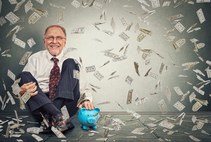 Man sitting on floor with piggy bank